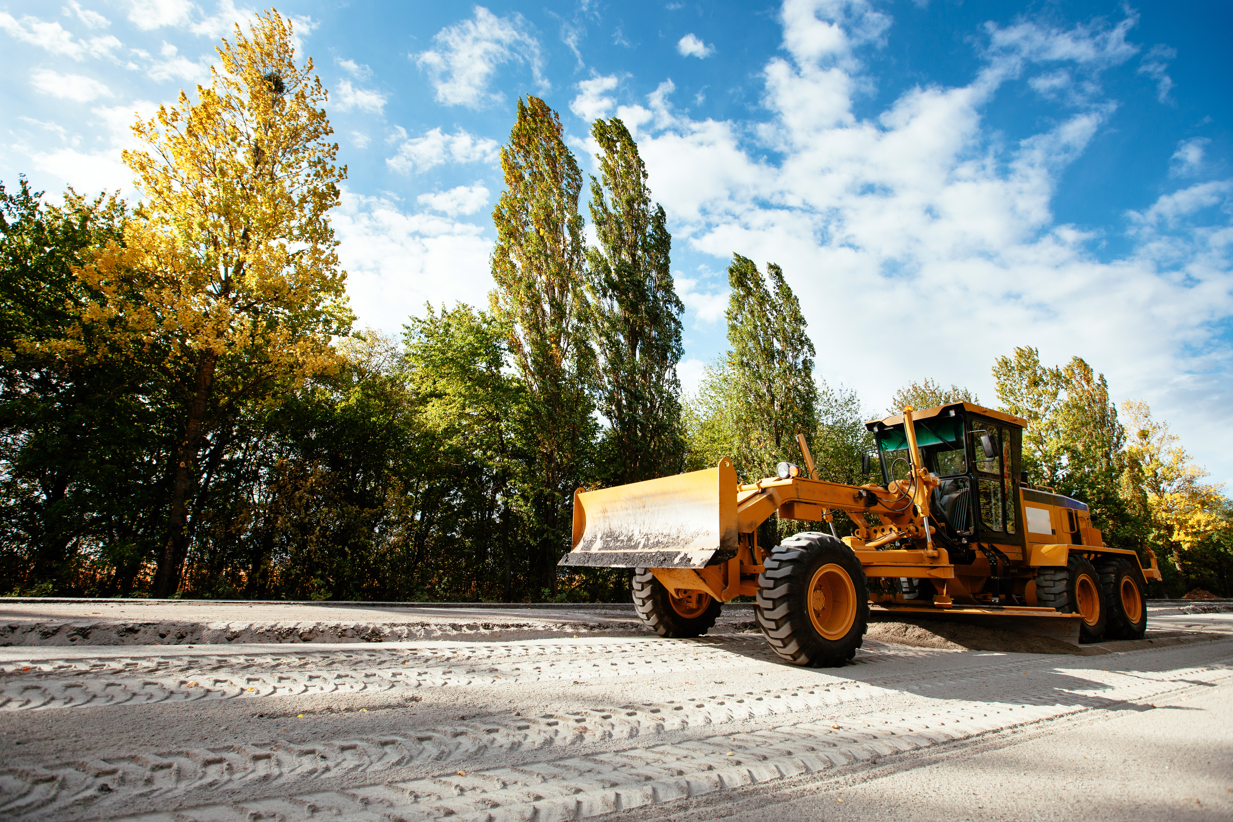 Grader značky CAT v teréne. 